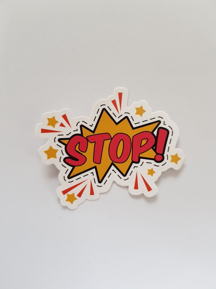 Bright and colorful sticker design featuring a comic-style Stop! sign on a gray background.